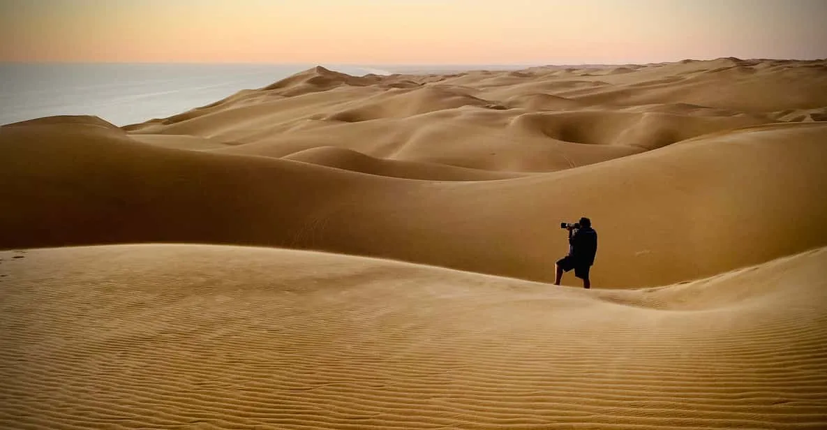 Low sun raking across dune ridges on a Sandwich Harbour sunset photography tour in the Namib Desert, Namibia